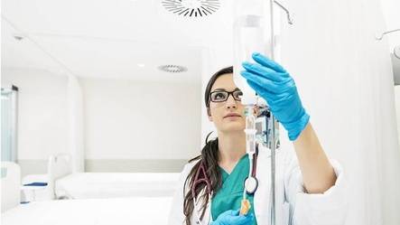Healthcare worker checking fluids in drip line