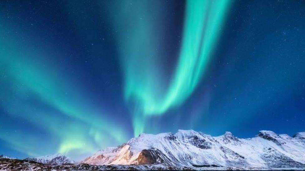 Aurora borealis over mountains and the water in Alaska