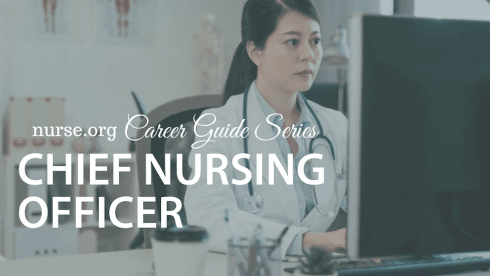 Doctor sitting at desk in office on computer